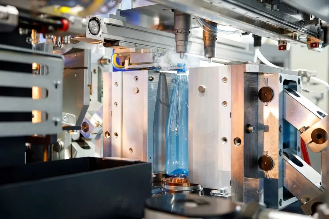 PET blow moulding machine forming a plastic bottle